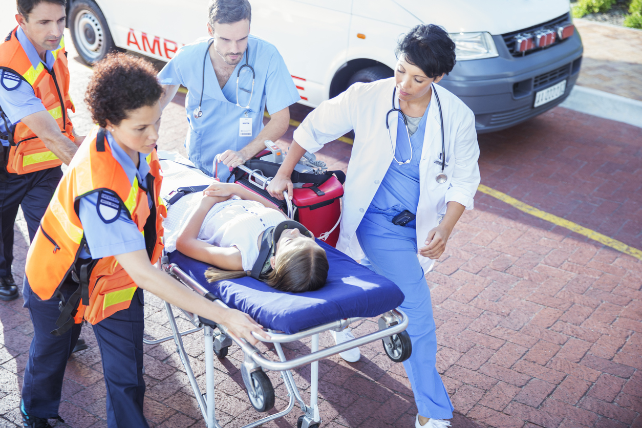 Doctor, nurse and paramedics wheeling patient on stretcher